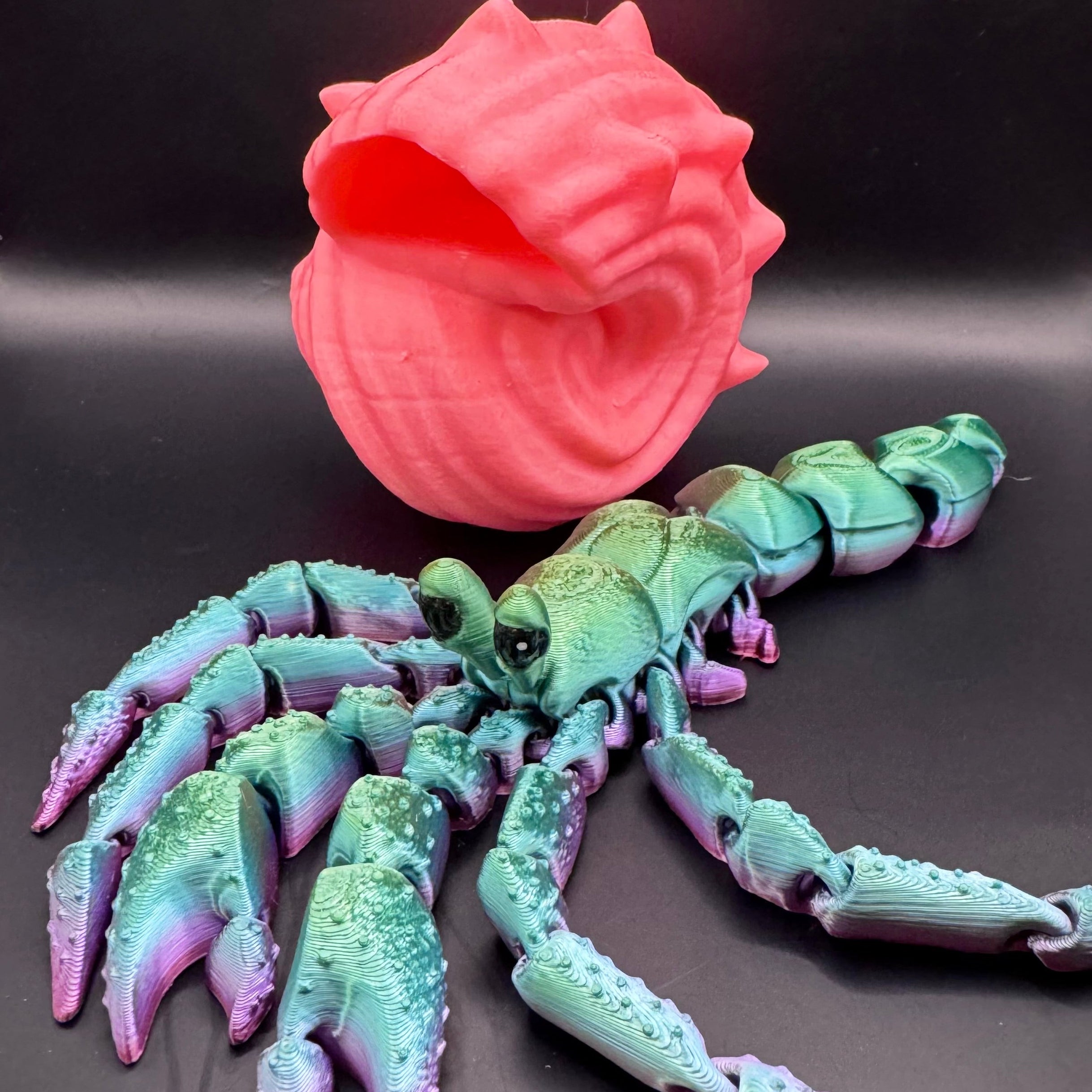 Green, blue, and purple ombre 3d printed hermit crab with pink shell 