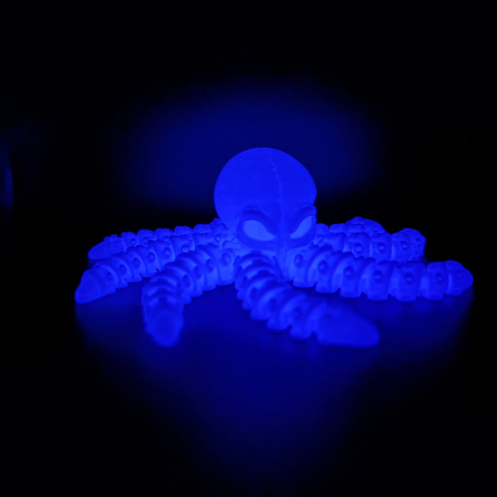Close-up of Ghost Current glowing blue in the dark, highlighting its luminous eyes and articulated tentacles. 