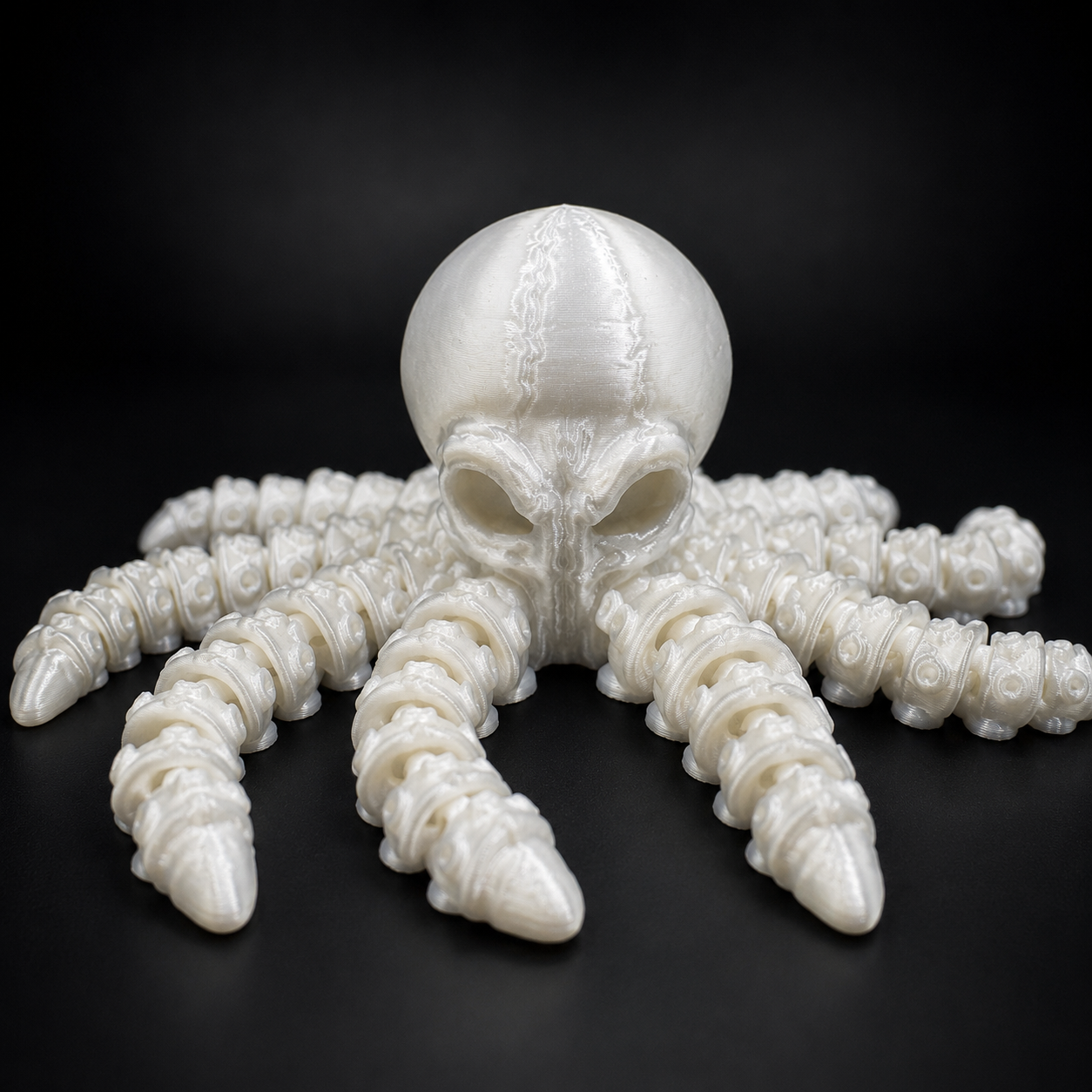 Ghost Current articulated glow-in-the-dark octopus companion in pearlescent white PLA with poseable tentacles on a black studio background.