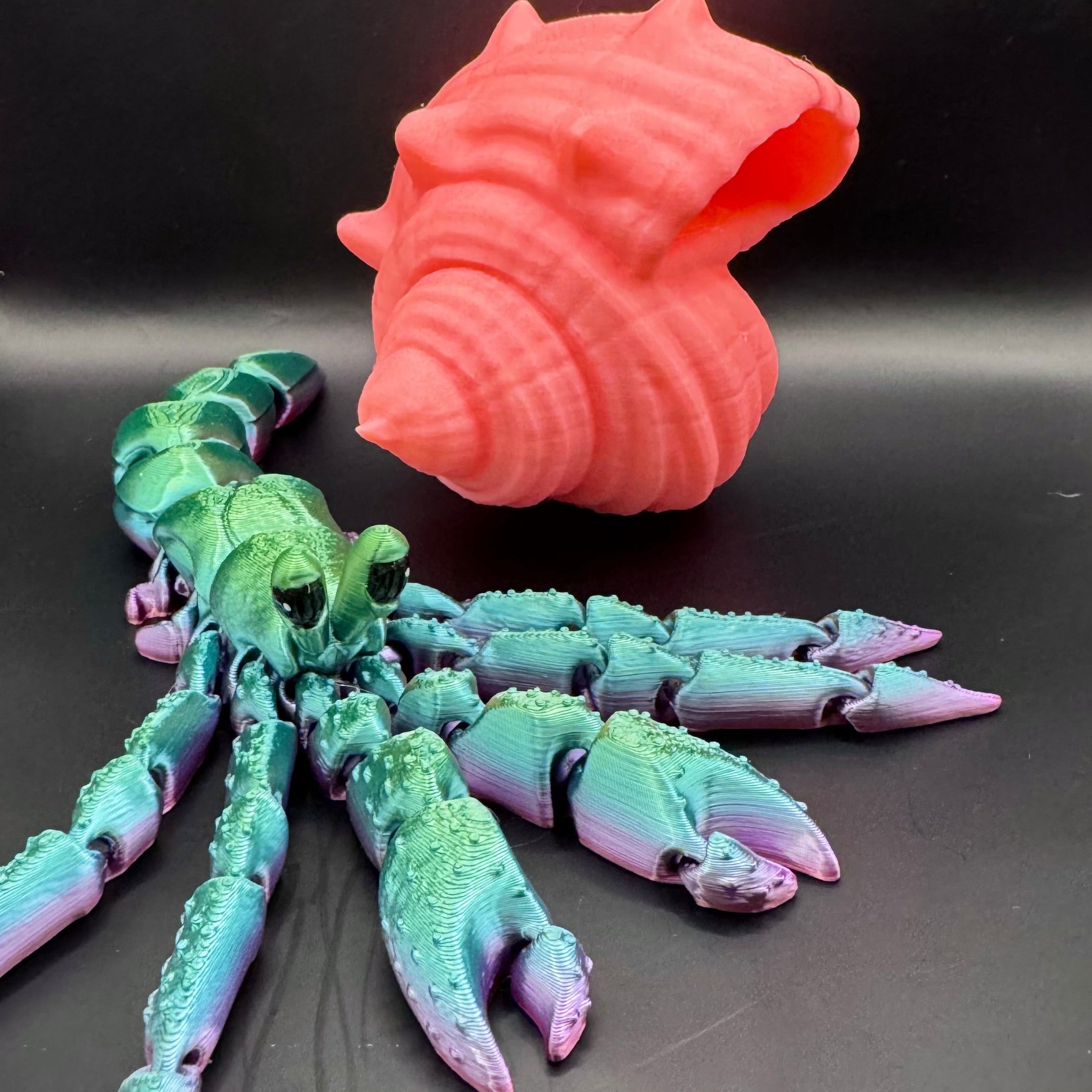 Green, blue, and purple ombre 3d printed hermit crab with pink shell 