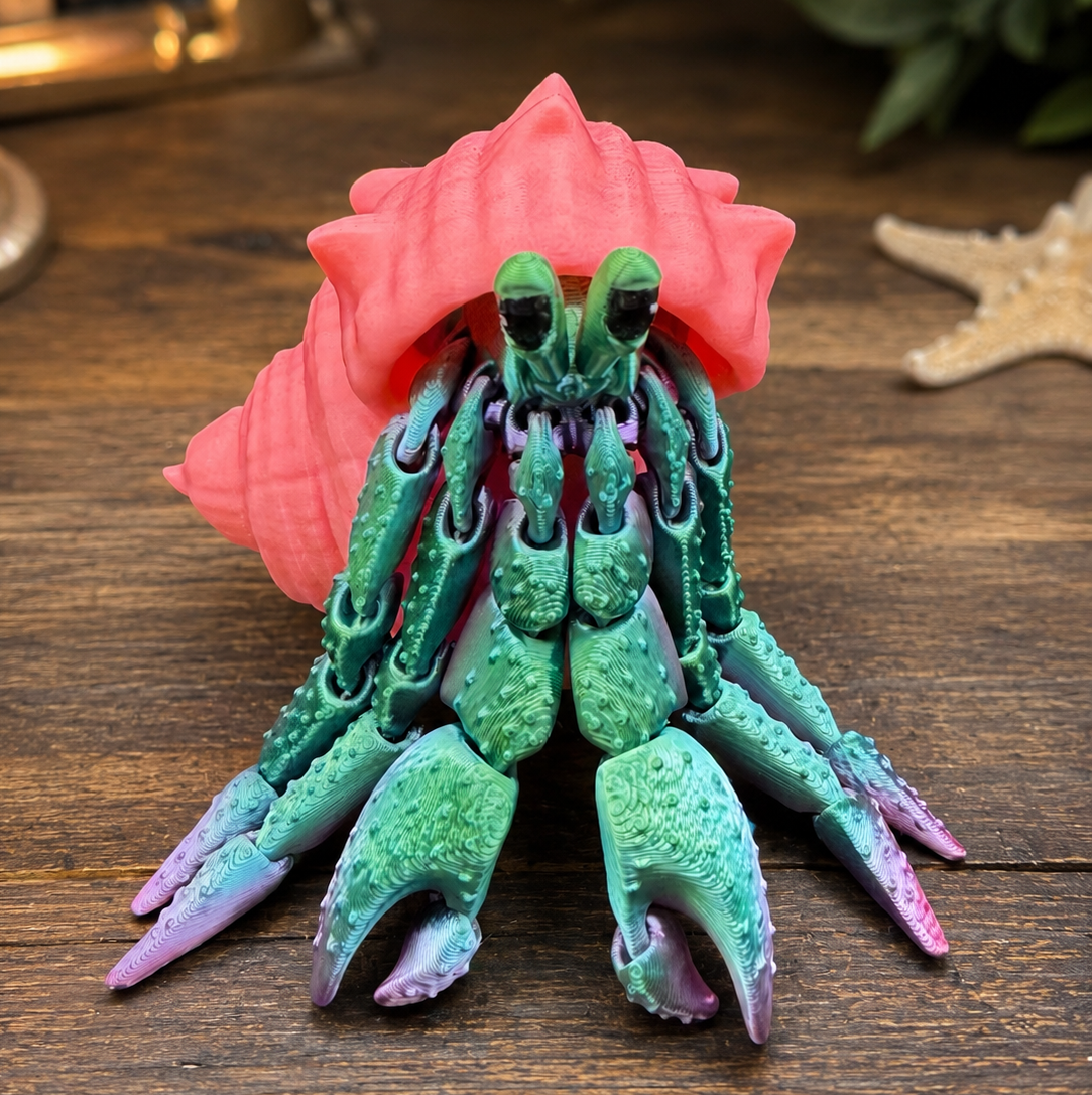 Green and purple ombre 3d printed hermit crab with pink shell on table top