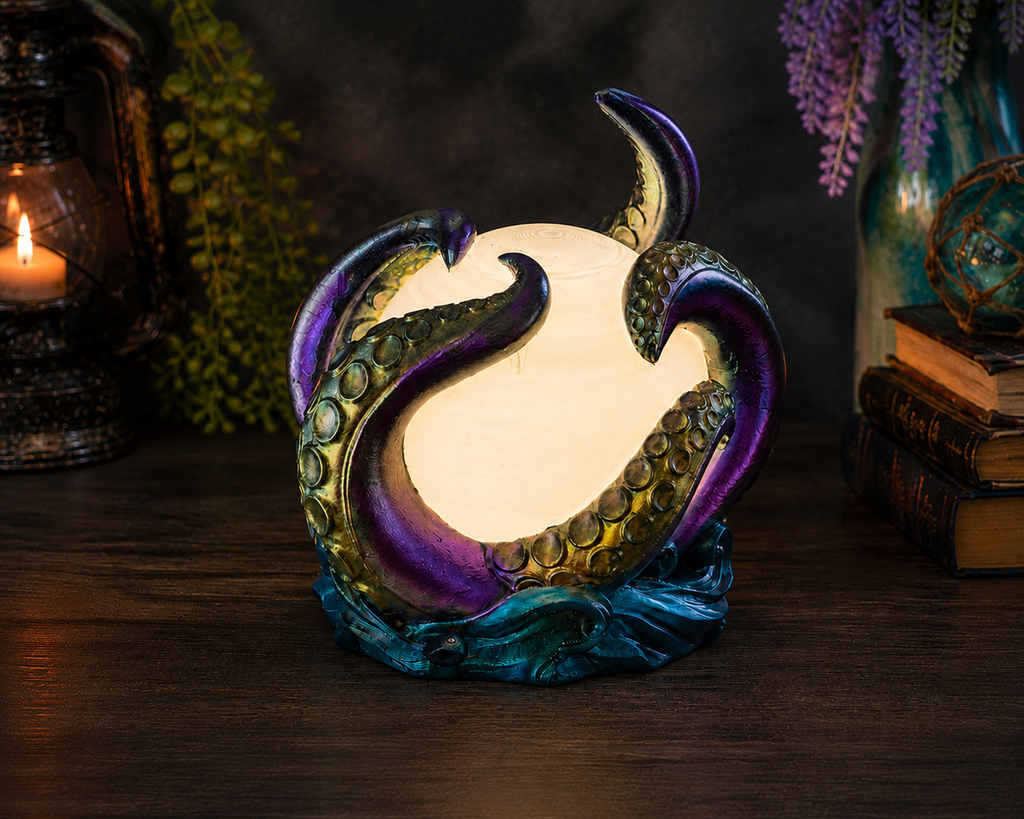Abyssal Glow octopus lamp illuminated in warm white light, showing hand-painted color-shifting tentacles and wave base.
