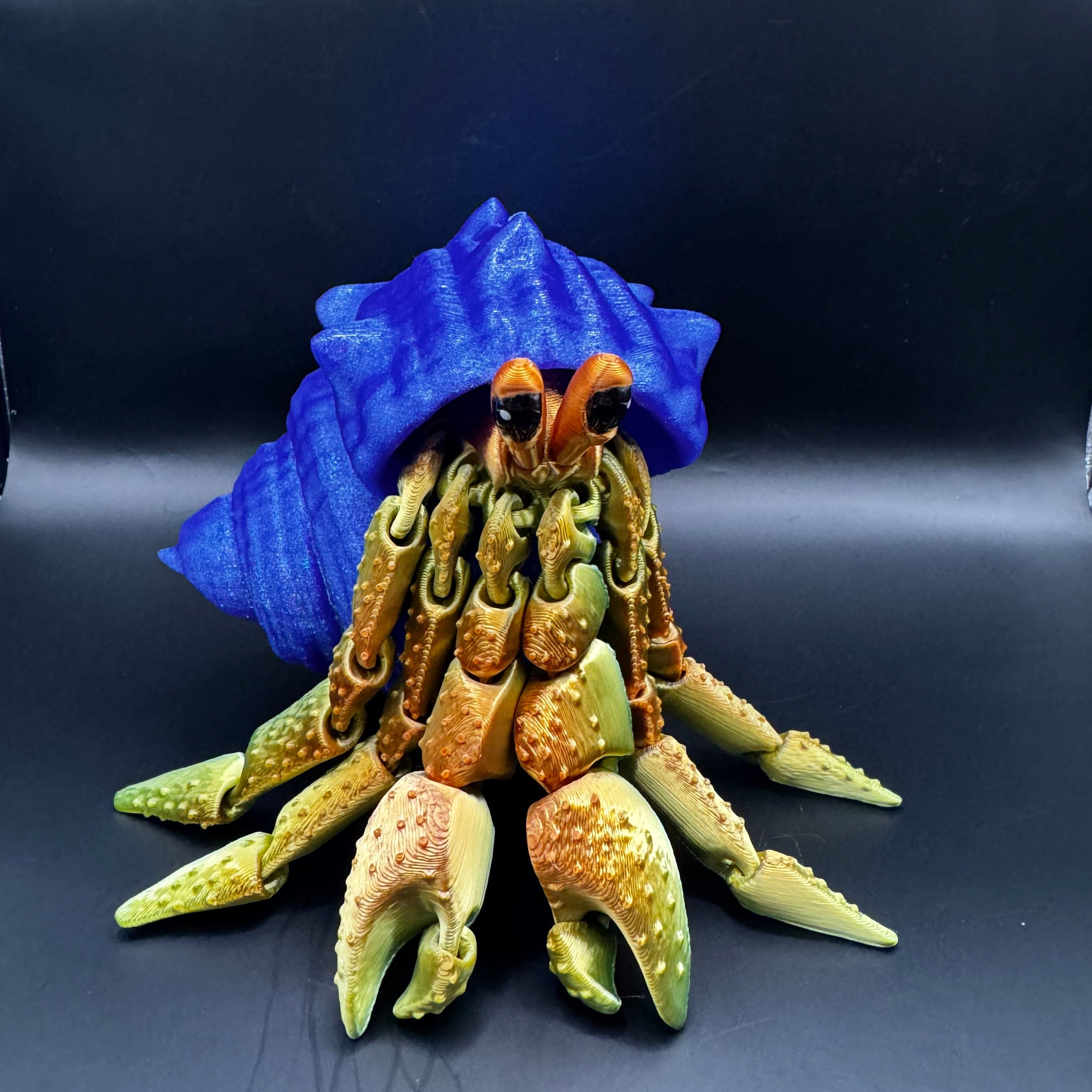 3d printed hermit crab with redish gold body inside a blue shell 