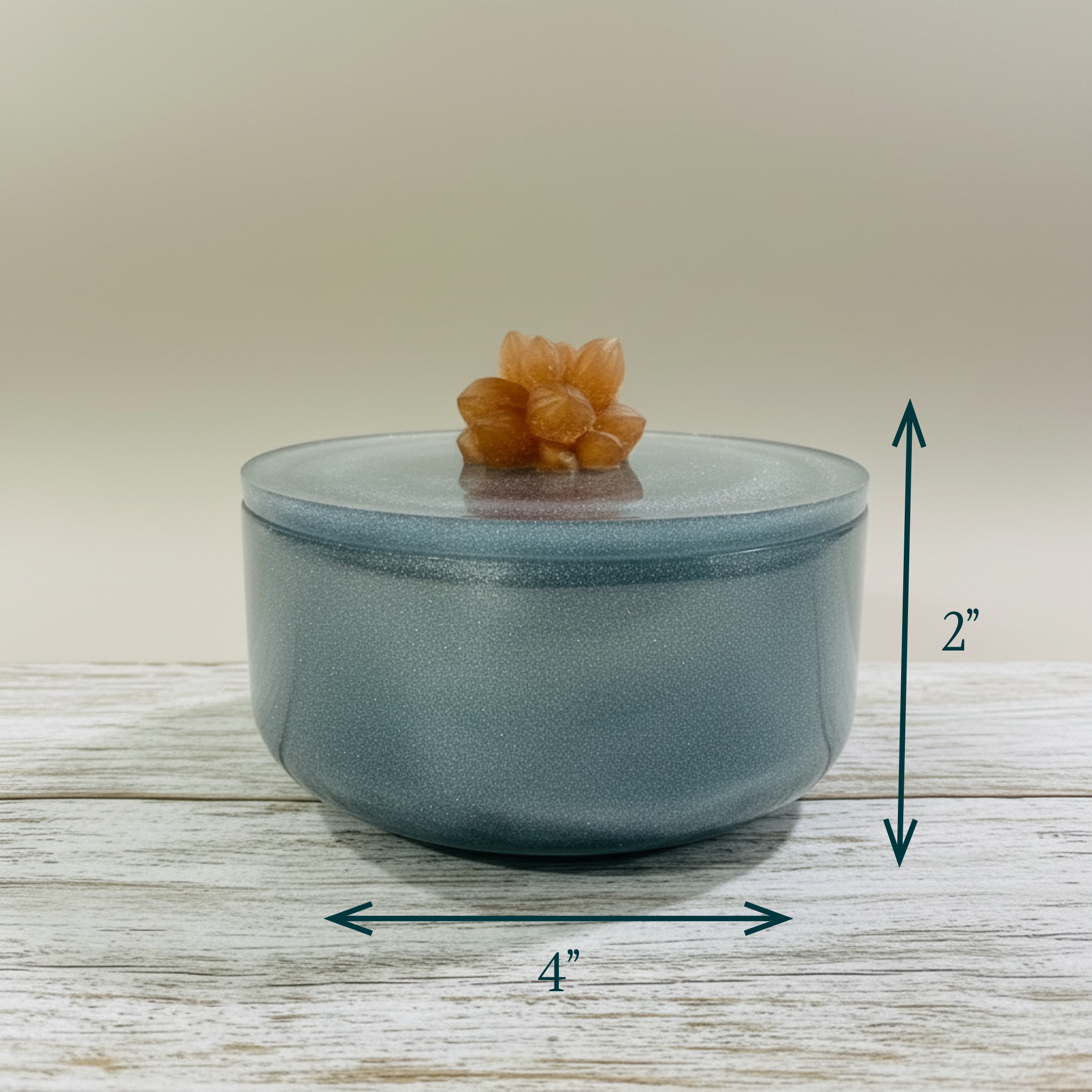 Vessel jar shimmer blue with caramel colored succulent on the lid displayed to show size 