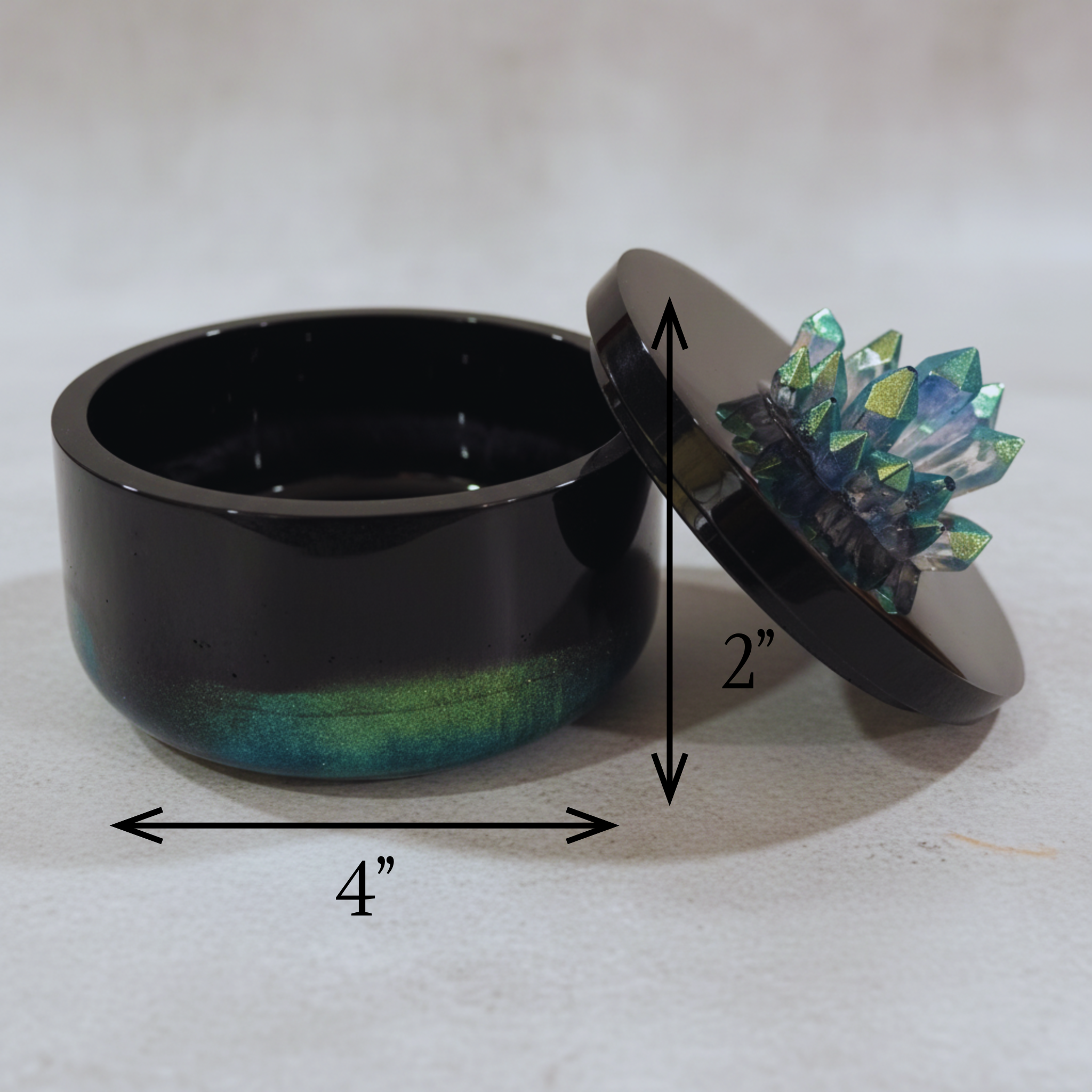 Black, green and blue color shifting resin jar with crystal cluster on lid displayed to show measurements