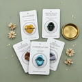 Set of worry stones with product ritual cards on a green surface 